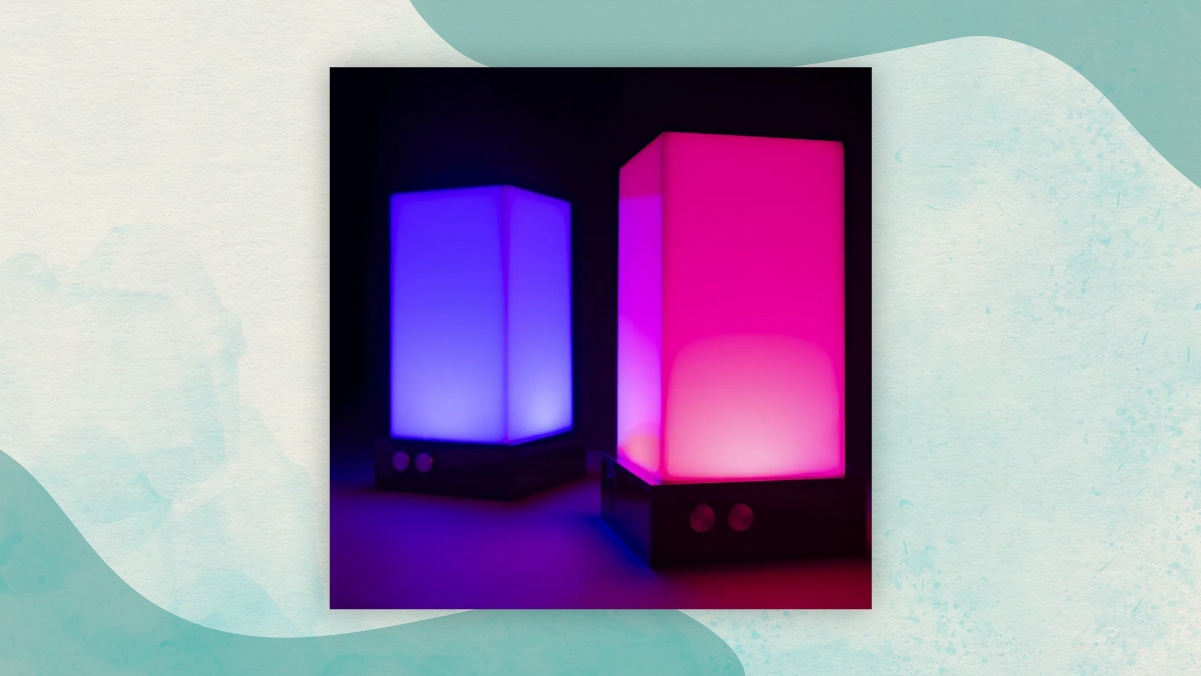 One pink and one blue colored illuminated touch lamp kept beside each other in a black background as perfect gifts for long distance relationships.  
