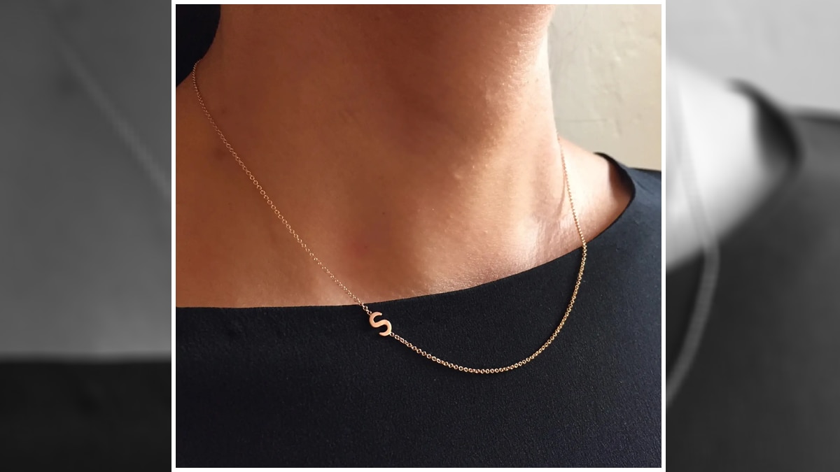 A women in a black top wearing a necklace with an S initial as mother's day gift ideas.
