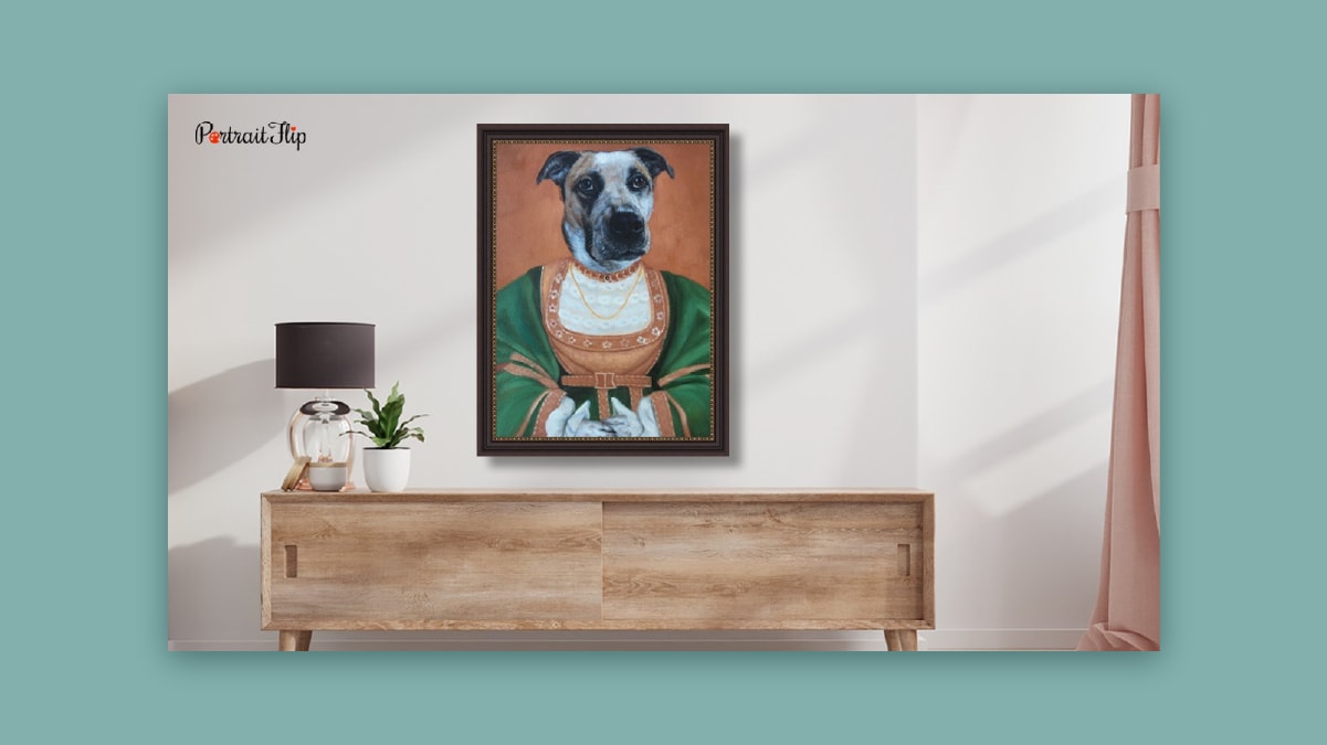 A dog portrait like a king hung on an off white wall above a cabinet. 
