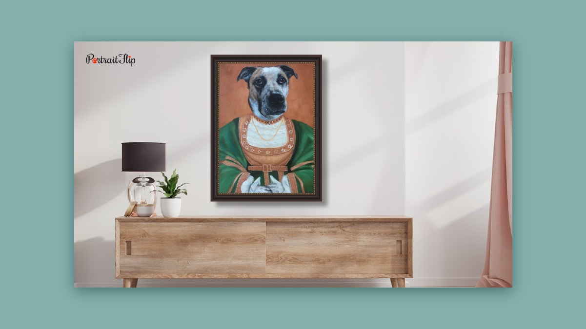 A dog portrait like a king hung on an off white wall above a cabinet.