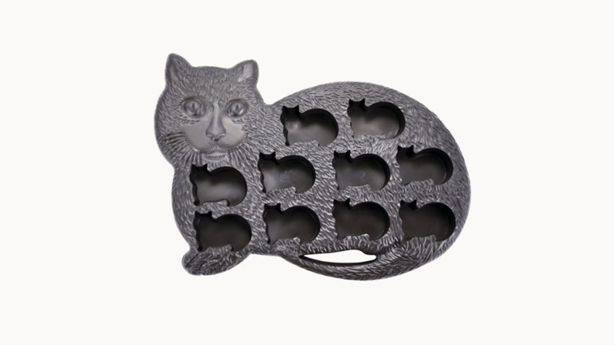 A cat shaped ice-tray with cat shaped ice cubes in a white background. 