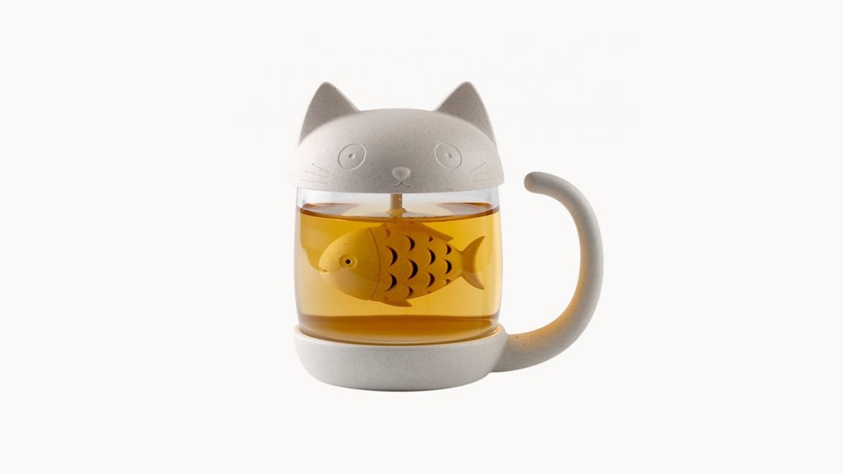 A cat shaped tea infuser with a fish rotor in a white background. 