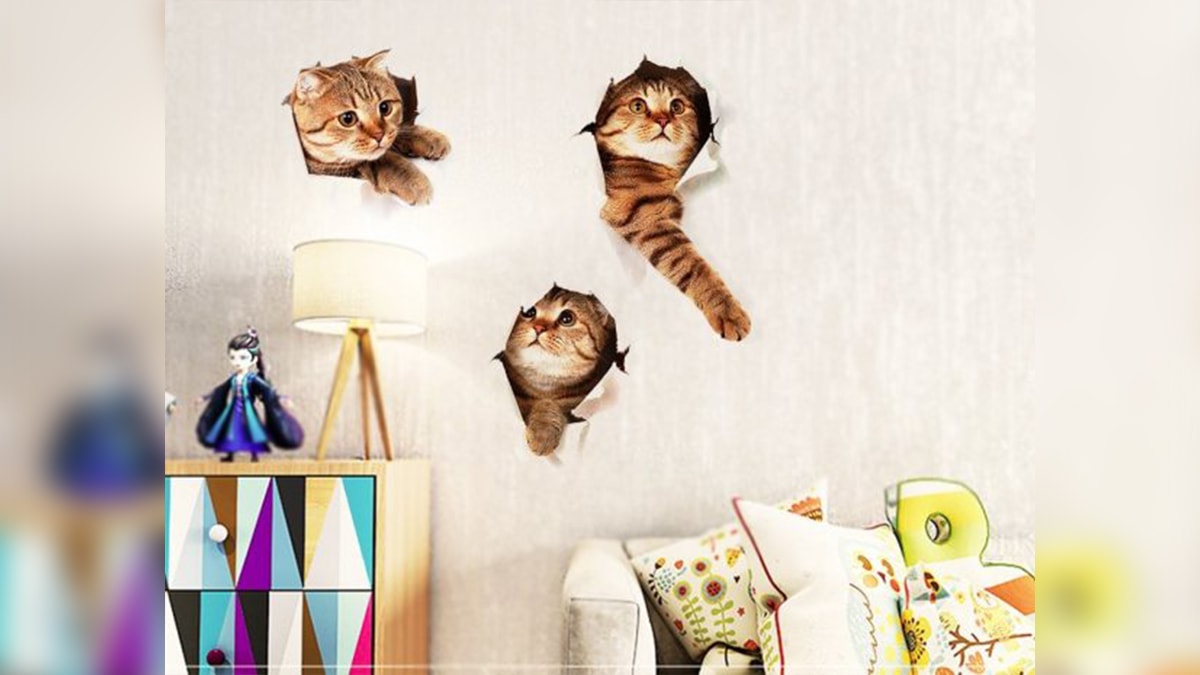 A kitten wall decor with three kittens peeping out of the window in a room. 