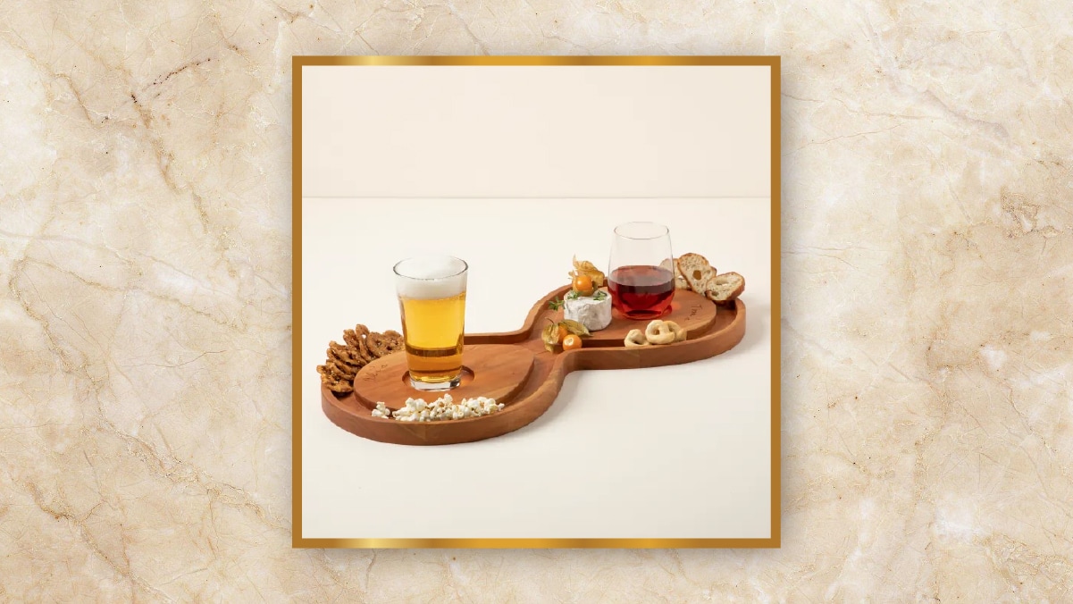 An infinity shaped snack tray with two glasses and some snacks. 