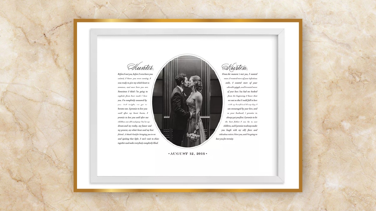 A white frame with black and white photo of bride and groom kissing each other in the center and their wedding vows on the right and left side as personalized wedding gifts. 
