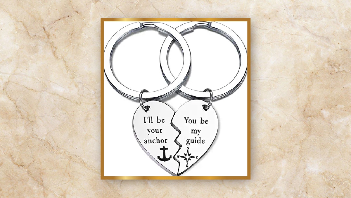 A pair of keychain with two half hearts kept in a white background.  