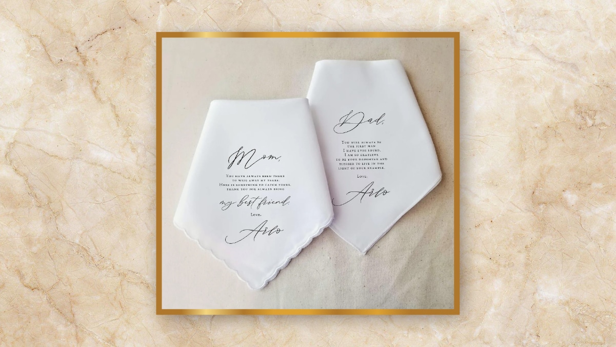 Two folded handkerchiefs with appreciation notes written on it kept on a light brown background as personalized wedding gifts.