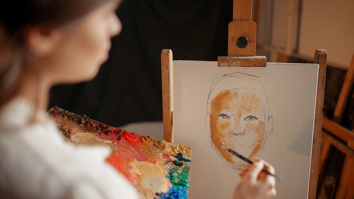 A girl is creating a painting of a man