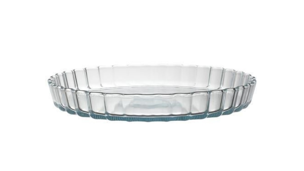 A glass pie dish is placed on the white and plain surface. 