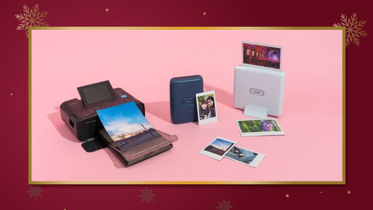 an instant photo printer with some photos lying on the floor