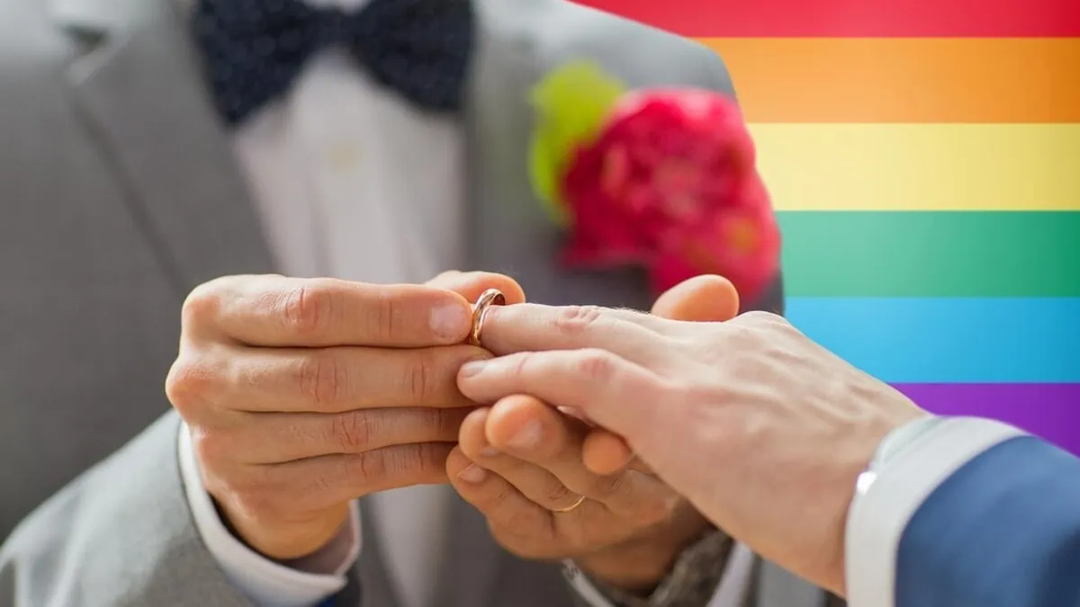 Close up shot of hands, where two men are exchanging rings as a gifts for gay men