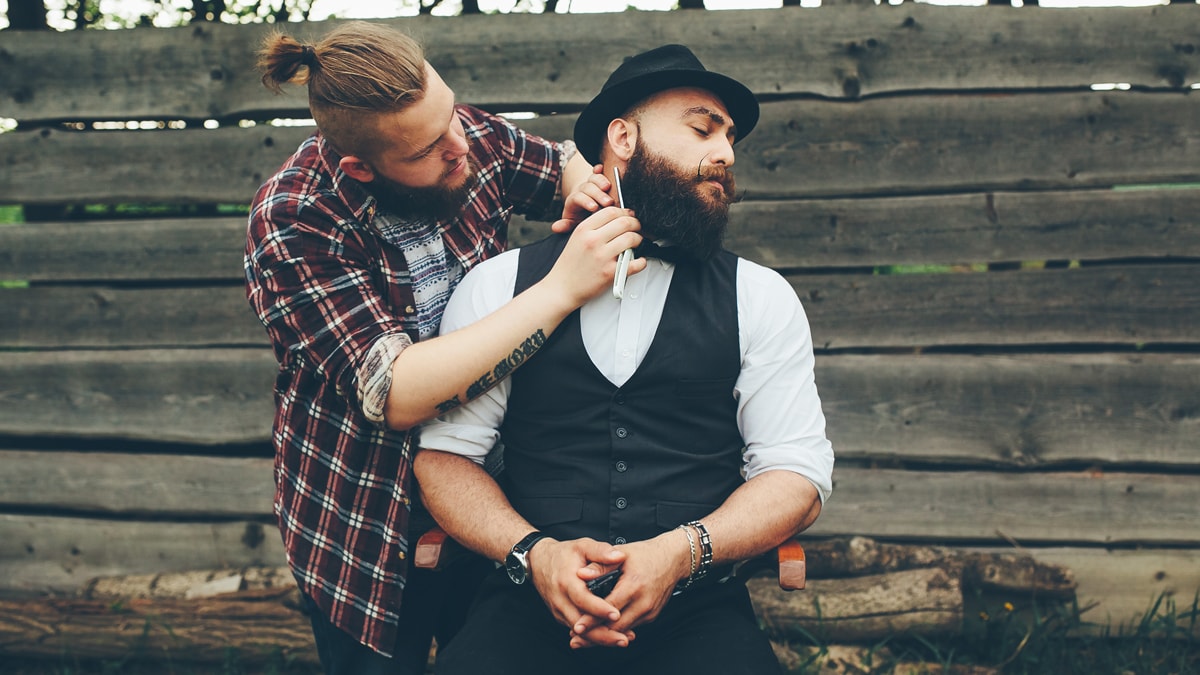 One gay man grooming another gay man with a kit which is a gifts for gay men.