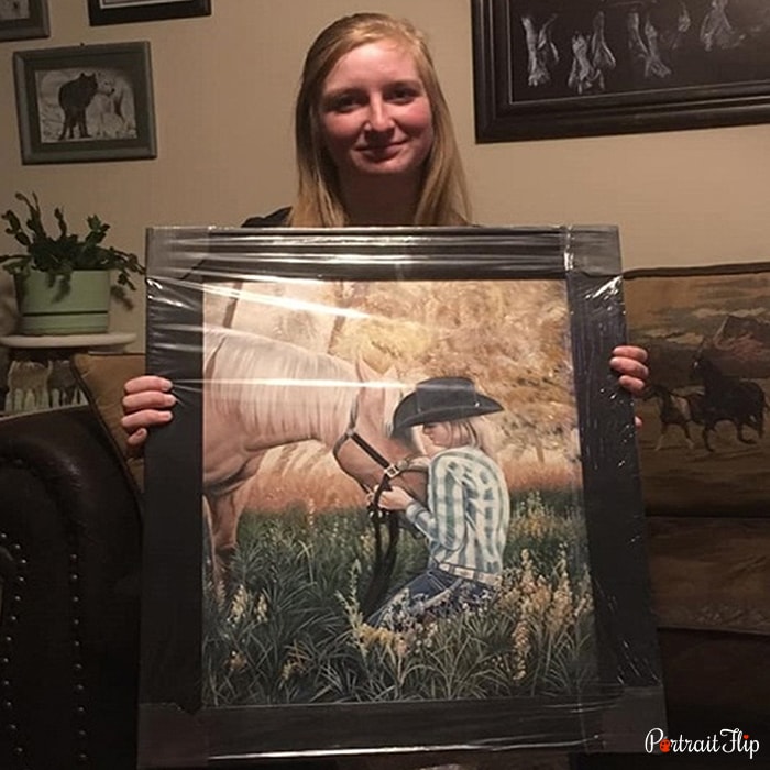 Picture of a girl who is holding a horse portraits in her hand that depicts a person riding a horse