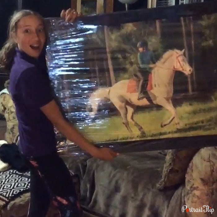 A woman shares her picture holding a horse portrait that shows a woman holding horse face in her hands