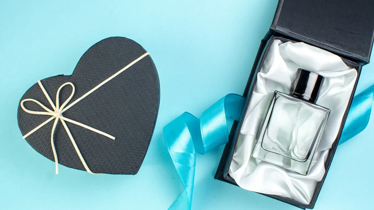 Two box, one in rectangle shape with a perfume bottle and another in closed heart shape on a blue background as a gifts for gay men.