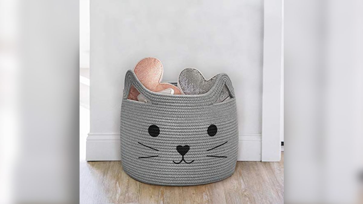 A grey colored cat basket kept on a wooden floor.