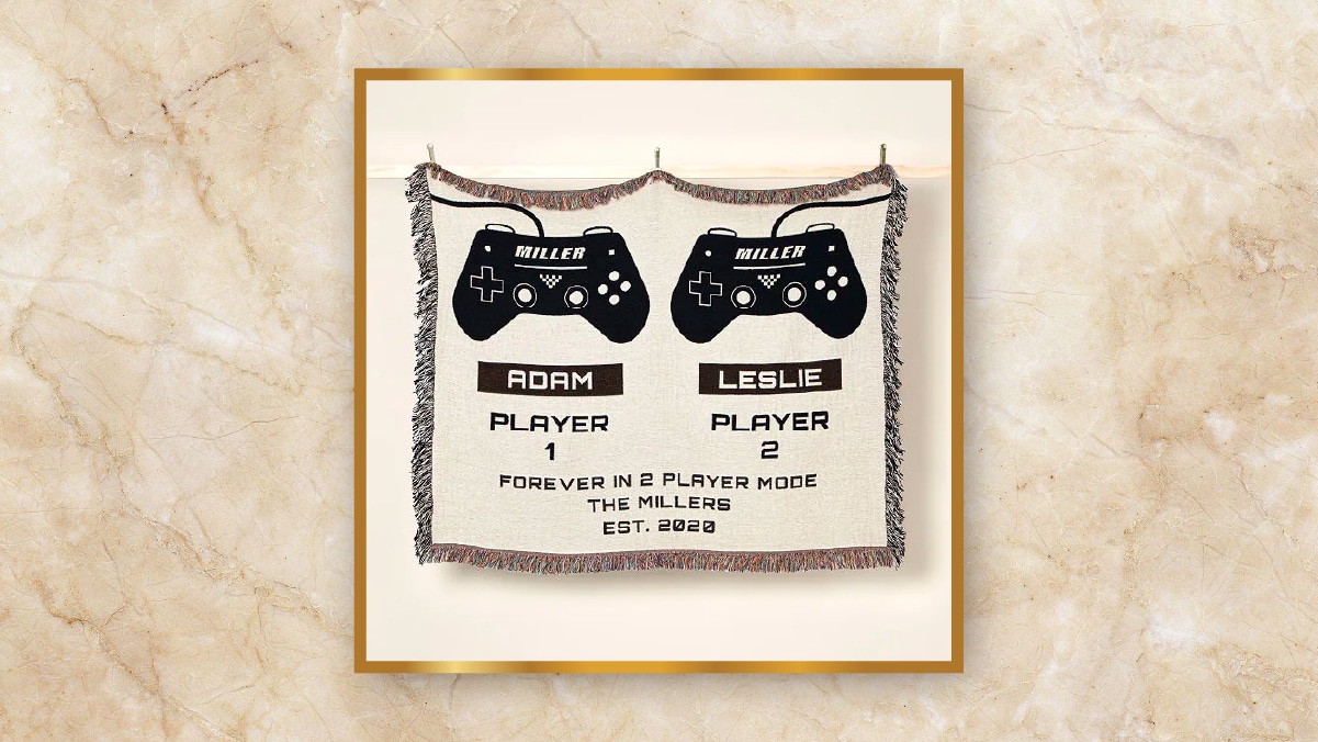 A blanket with two game controller printed on it in an off-white background. 