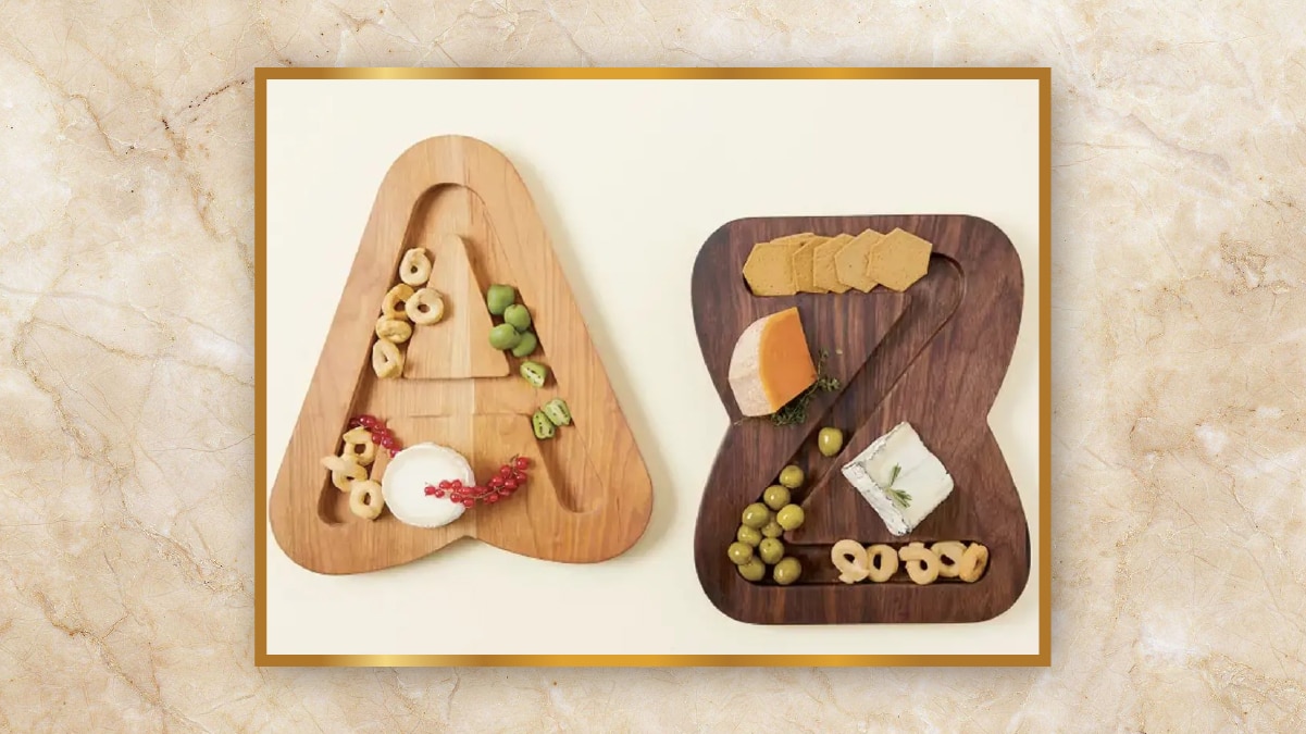 Monogrammed serving boards with letters A and Z with fruits on it kept on an off-white table as personalized wedding gifts. 