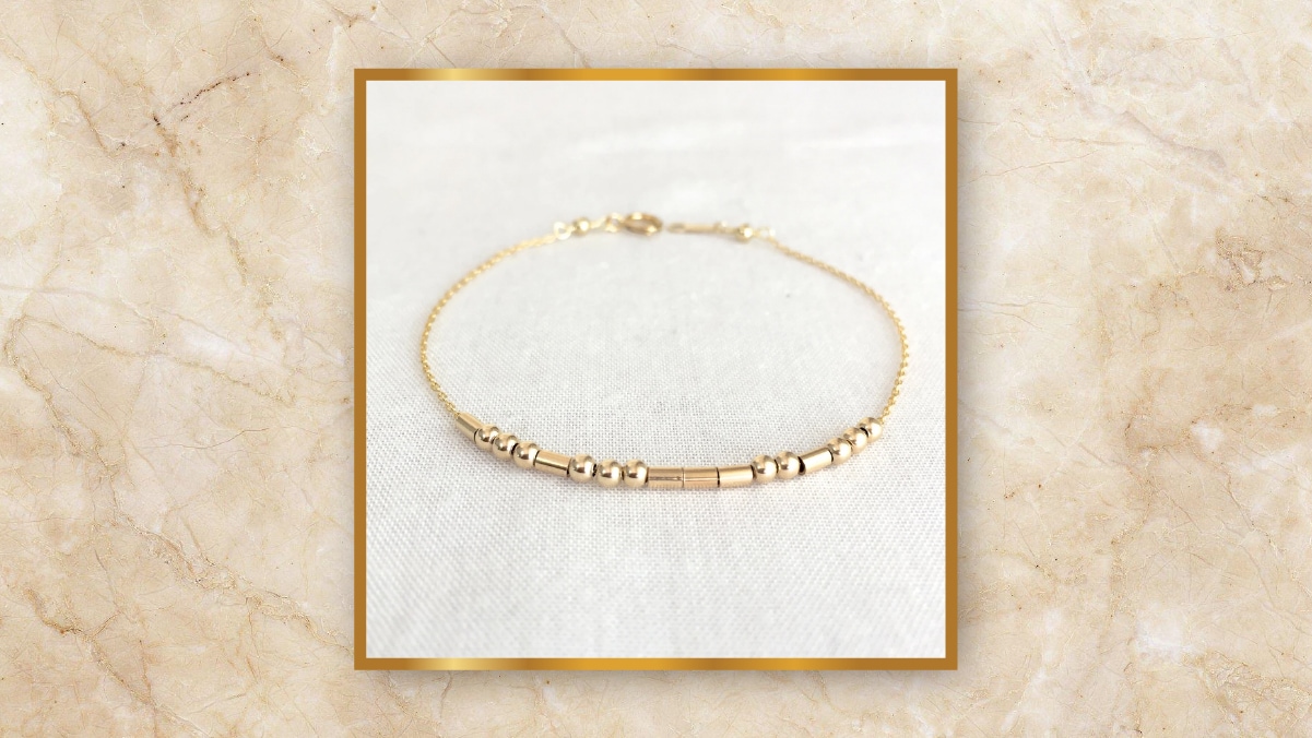 A golden bracelet on a white background. 