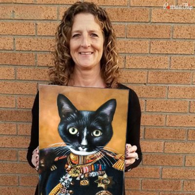 Picture of one of the happy customer who is standing with the royal pet portraits she has received of her cat where her cat is on the couch