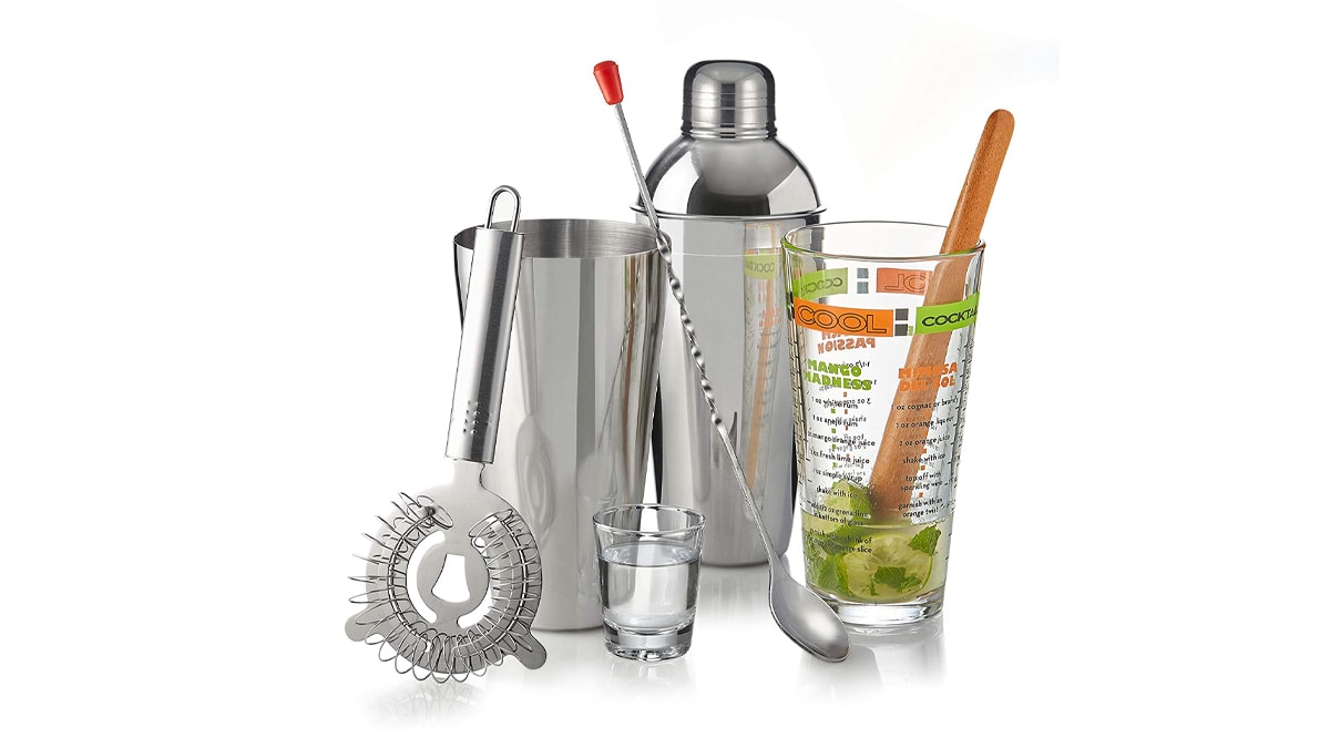 Shaker, fine strainer, jiggers and whisky shot glass in a white background.