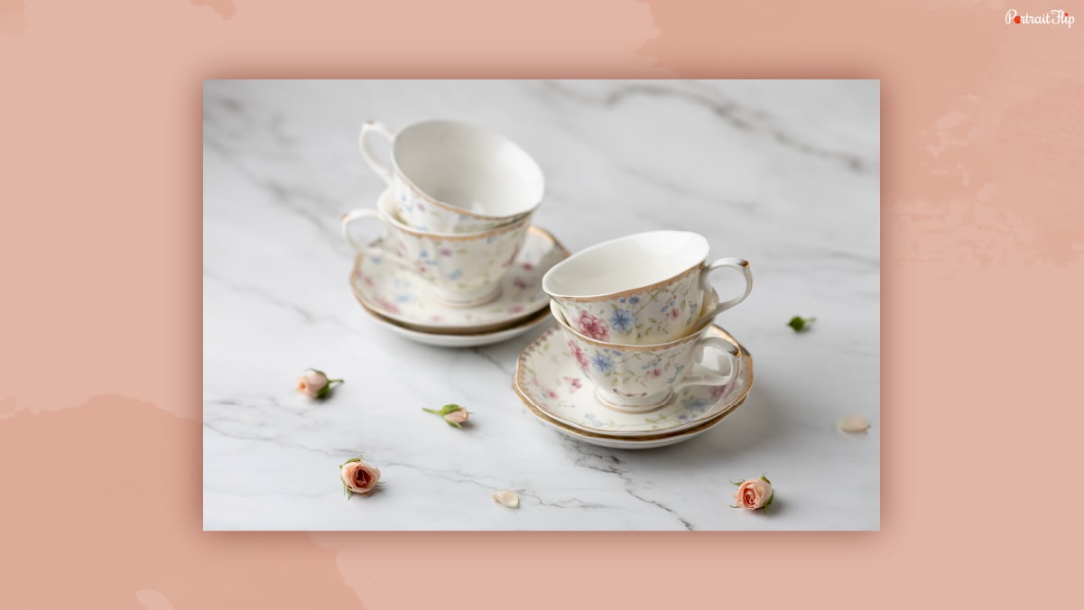 Set of teacups and saucer placed on a marble texture table that could be one of the thank-you gifts for women.