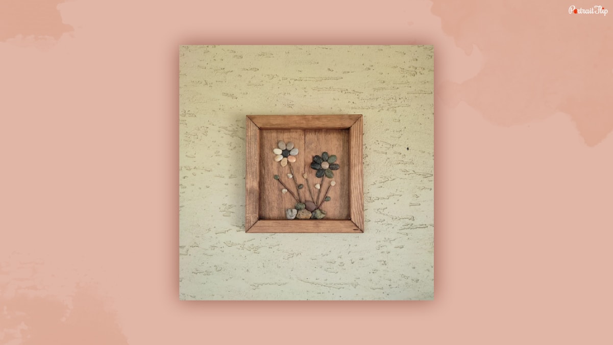 A small wooden frame with a pebble flower art included.