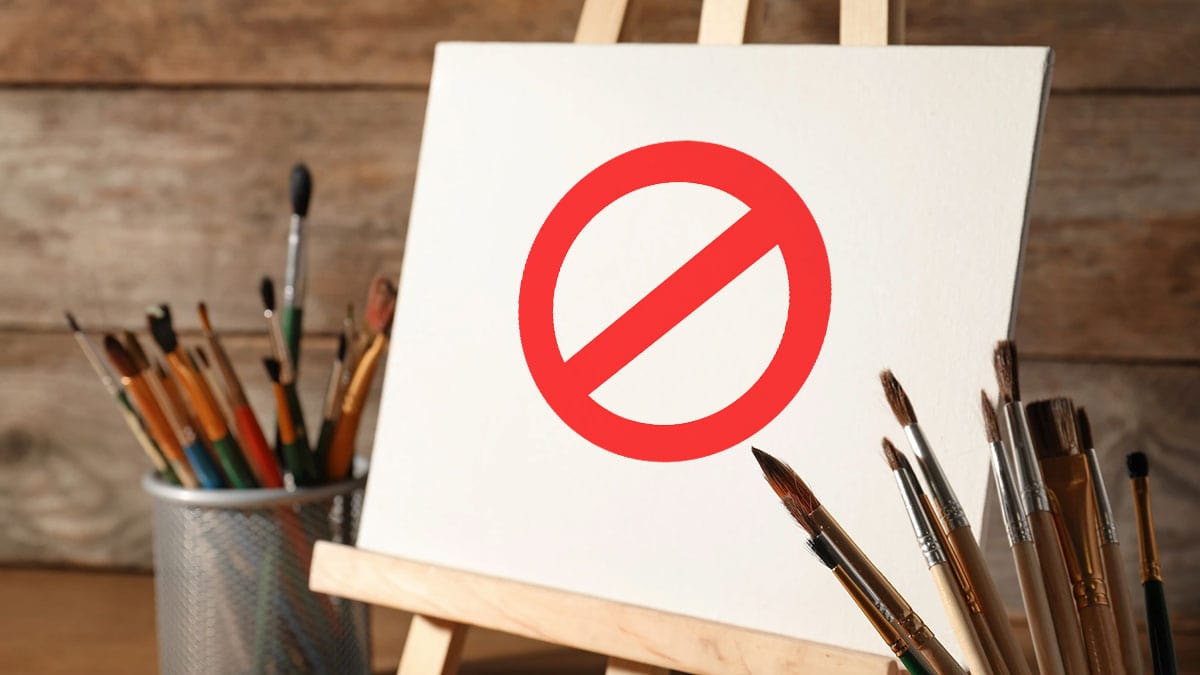 A blank canvas with a no-entry sign on it and with brushes in the brush holder. 