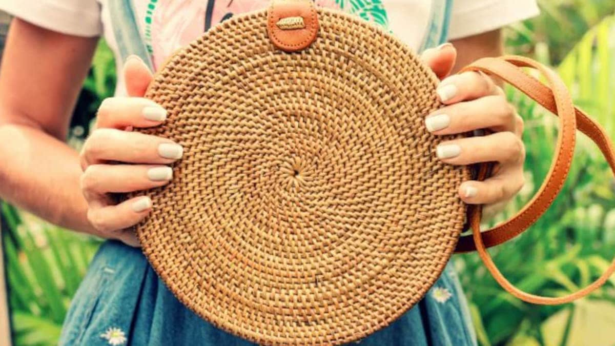 A woman holding a eco-friendly jute bag that is brown in color