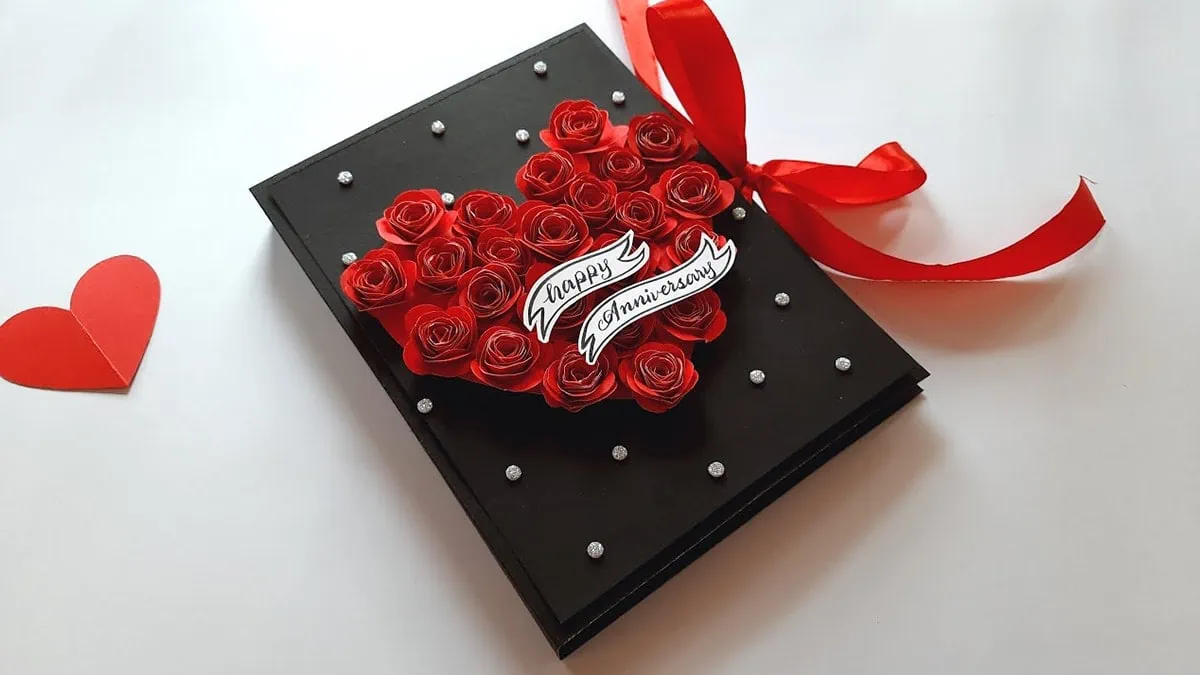 a special handmade black color anniversary card. The card has a heart detailing on the front side that are filled with paper roses