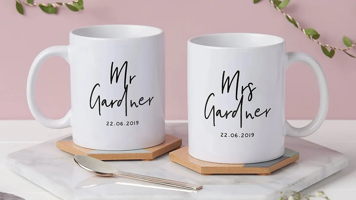 personalized mr and mrs cups in white color placed on a marble platform 