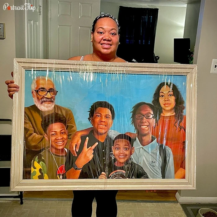Picture of a woman holding a family portraits that include an old man in the left corner, four boys in between and a woman in the right corner
