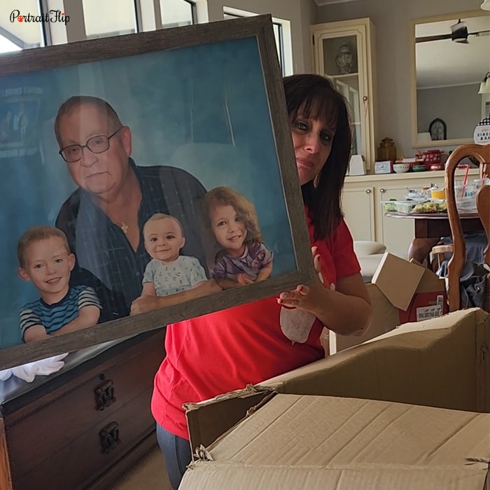 Picture of a woman holding merged portraits that show a man with a young girl and a boy, along with a baby in between