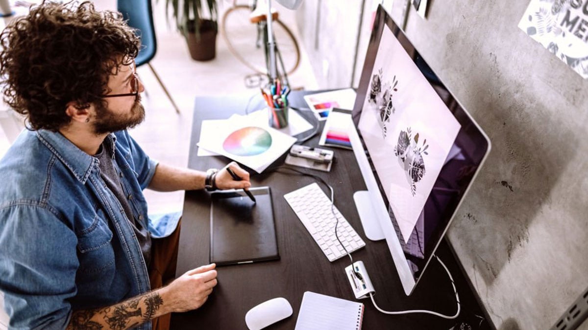 A man creating digital art using his gadgets and digital equipment.
