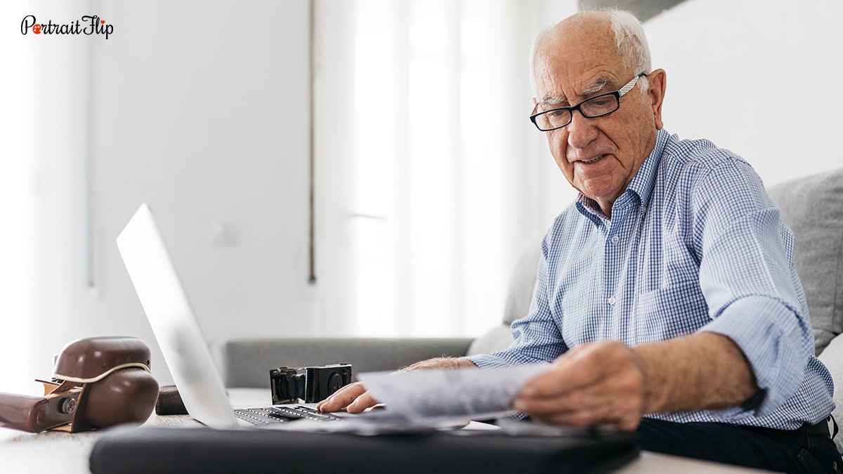 Picture of an old man looking at photographs