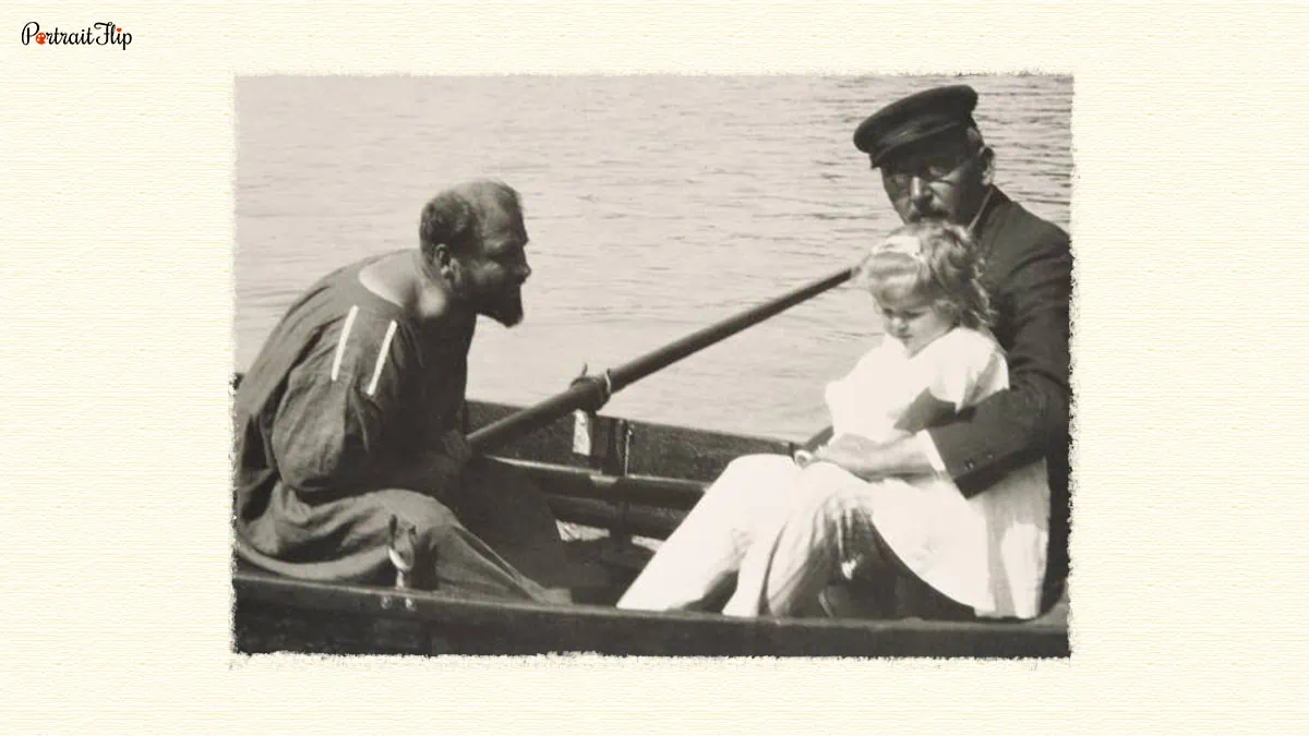 Gustav Klimt sitting in a boat with another man and a little girl. 