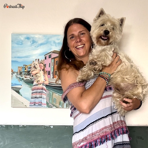 Picture of a woman holding dog in her arms with a painting that shows them in the same pose in the background