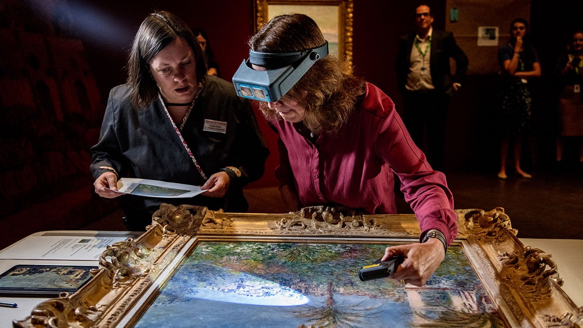 two art conservators working on a traditional art