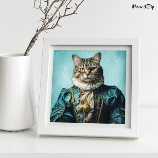 Portrait of a cat dressed as a queen is placed on a white table