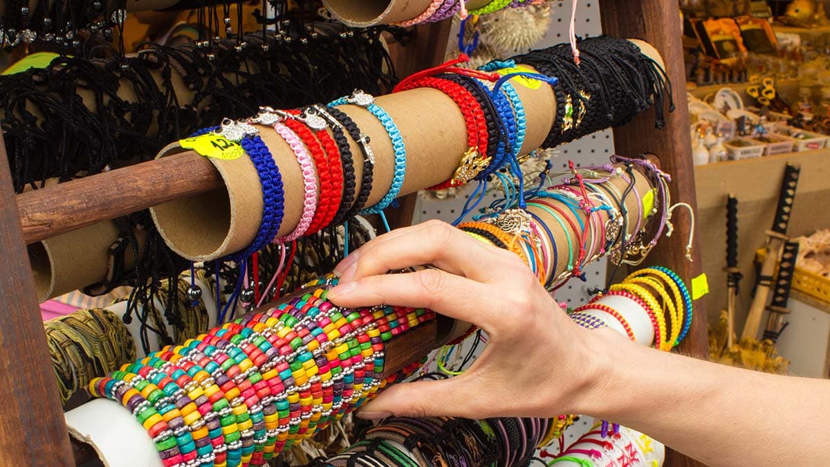 a close shot of man picking bracelets from cascade