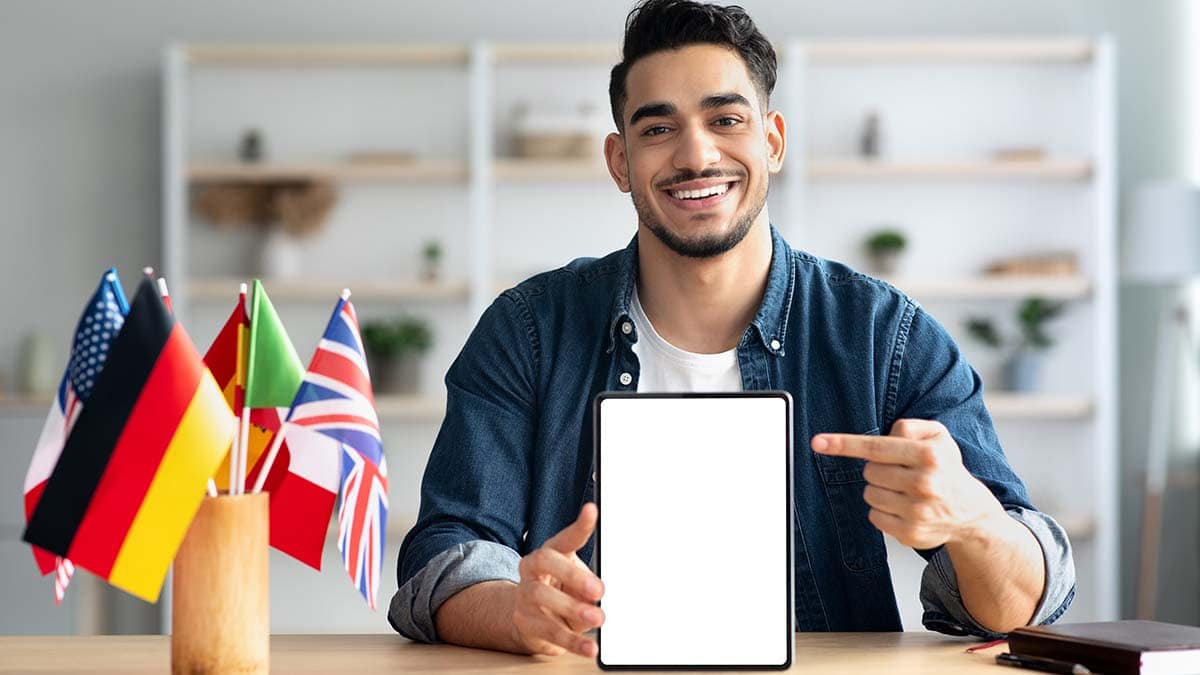 a guy smiling at the viewer pointing to a tab held below his chest