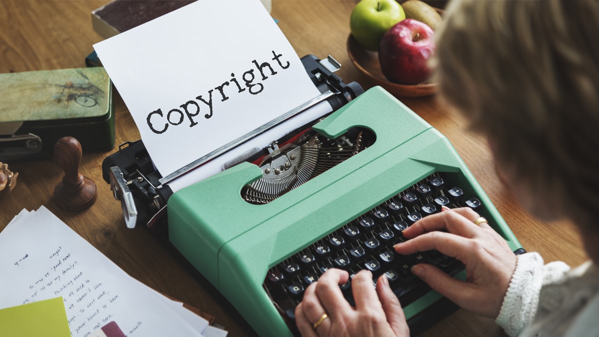 a typewriter typing out a paper with copyright written on.