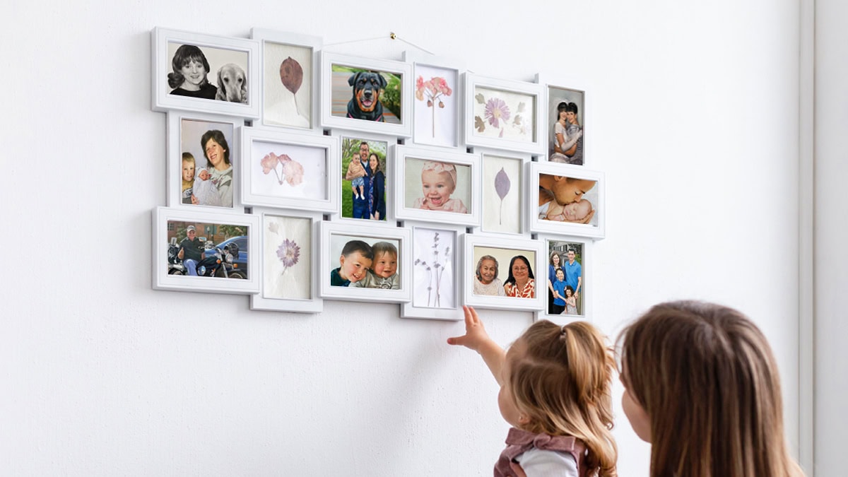 A mother and daughter looking at the painting frames arranged on the wall