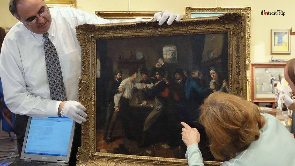 Two people examining painting