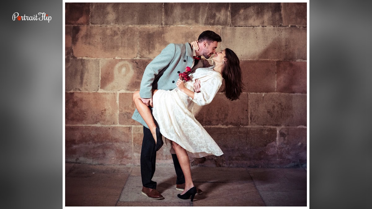 In this image you can see a couple striking a dance pose for camera