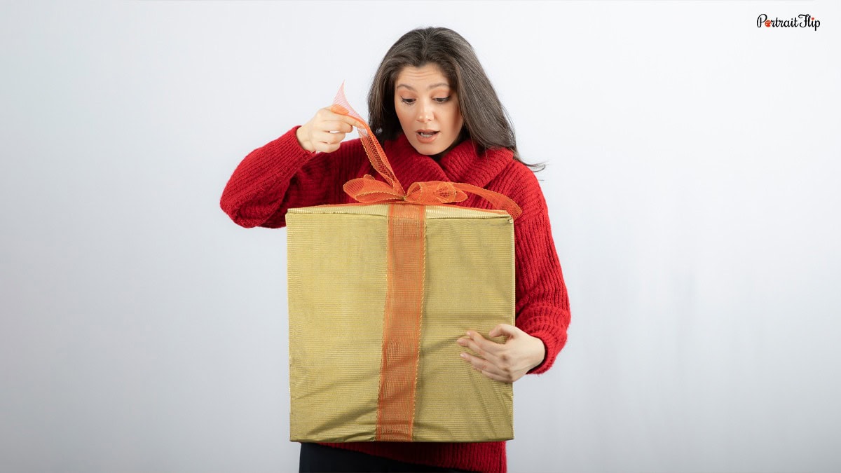 a lady in a red sweatshirt unwrapping an anti AI gift box