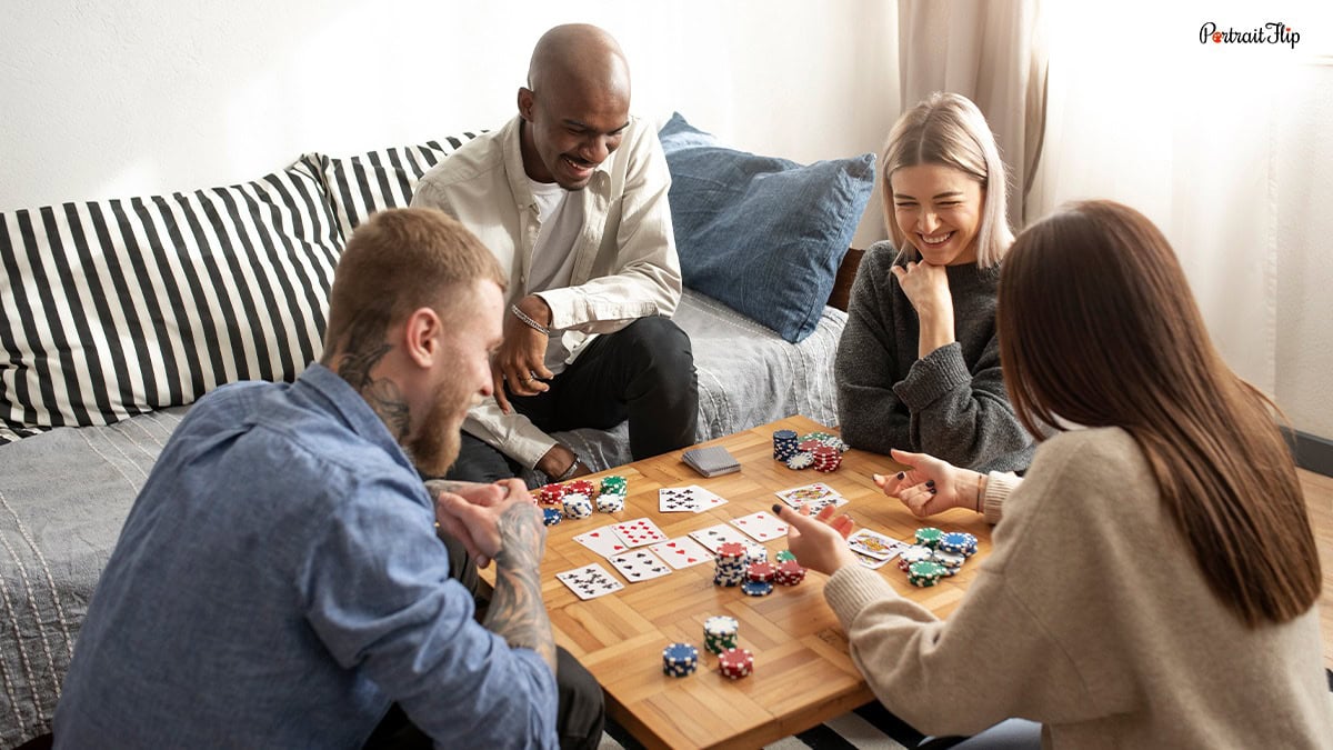 a group of four smiling, chattering, and playing card games