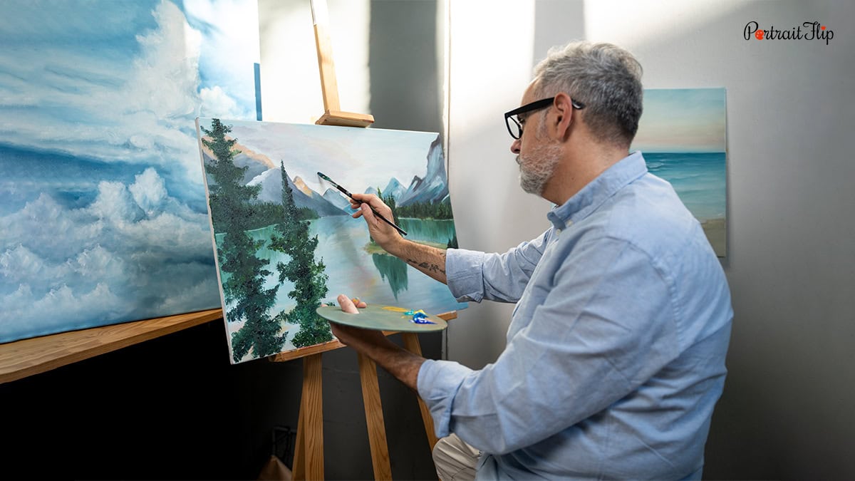 A man painting scenery on canvas