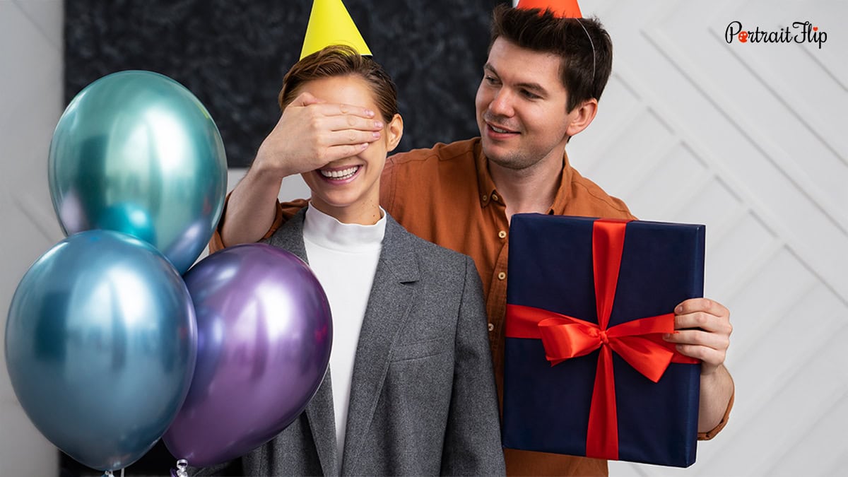 A man surprising a woman with gifts and balloon