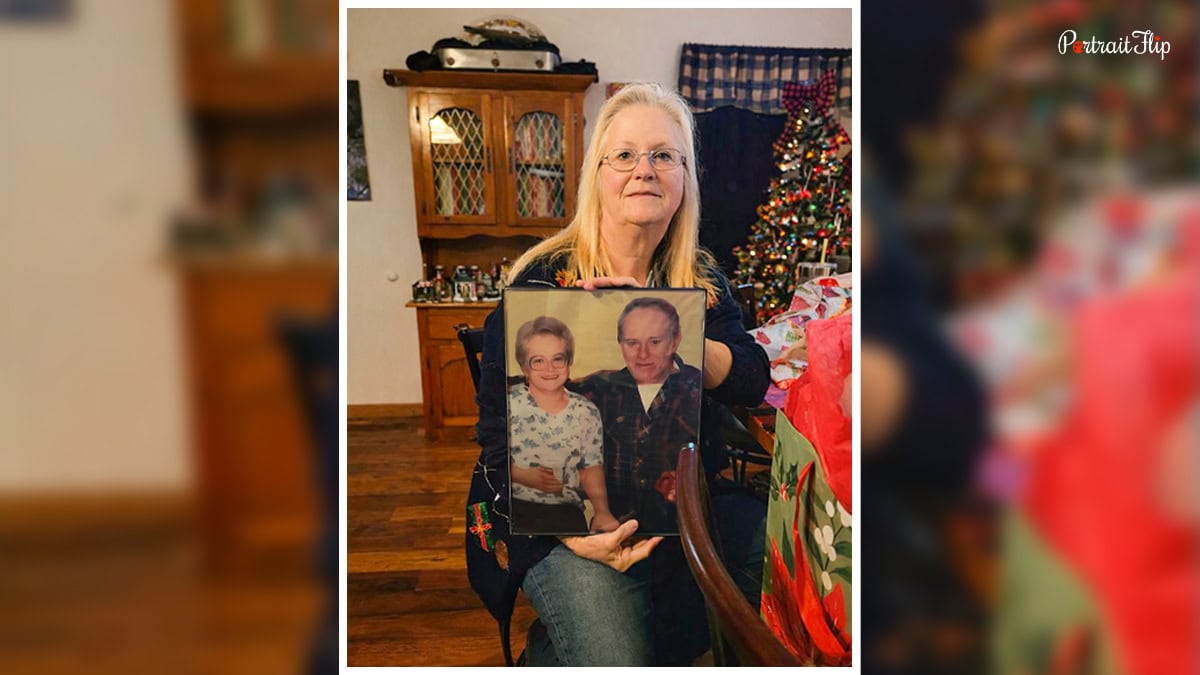 An old woman with a Vintage handmade portrait in her hand